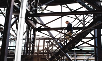 Employee walking up a staircase in a power plant