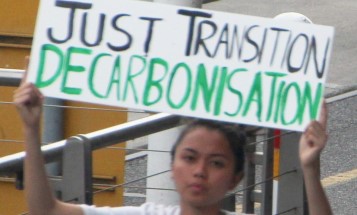 Protester holding a sign saying "Just Transition. Decarbonisation." at the Melbourne Global climate strike on 20 September, 2019.